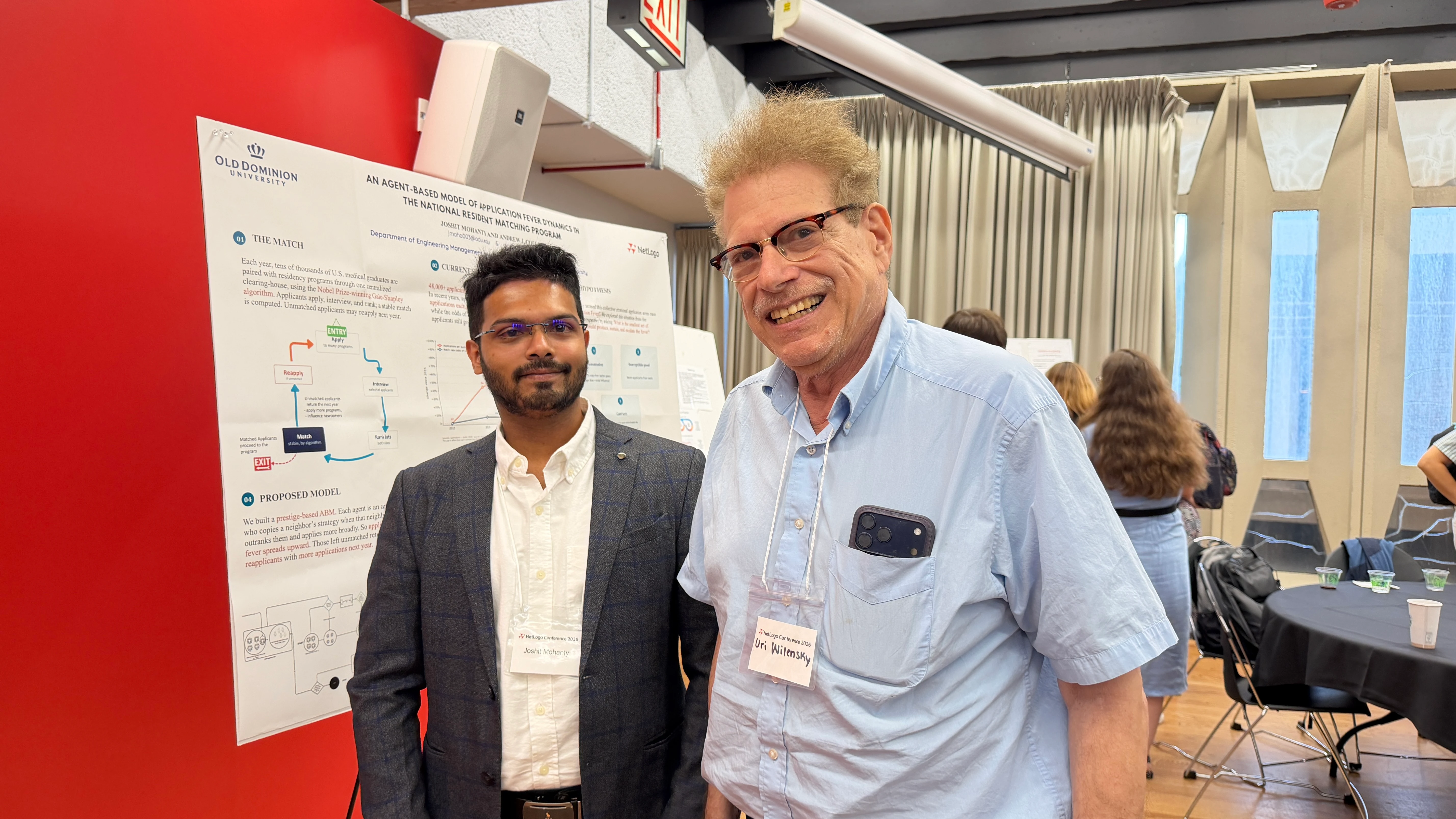 Joshit Mohanty with Uri Wilensky, creator of NetLogo, beside the application-fever poster at the NetLogo Conference 2026